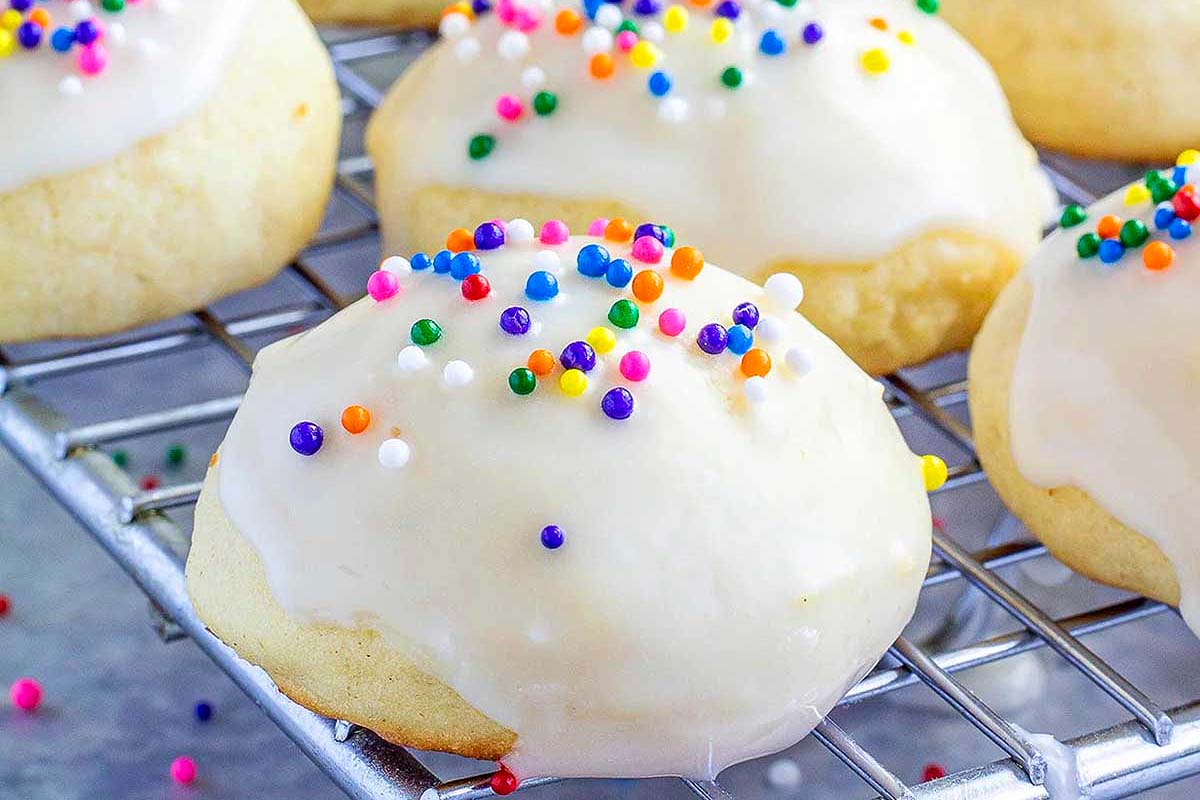 Frosted ricotta cookies decorated with colored sprinkles.