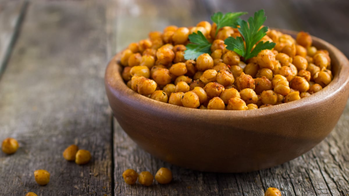 Roasted spicy chickpeas on rustic background.