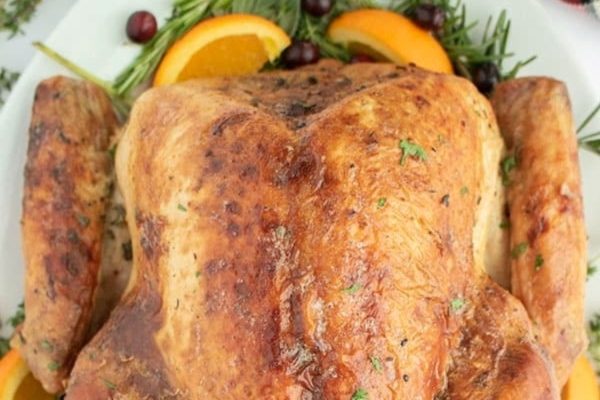 Roasted Thanksgiving Turkey served on a plate with herbs. 