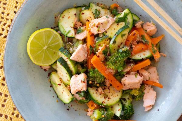 Salmon Stir-Fry with lemon slice and chopsticks.