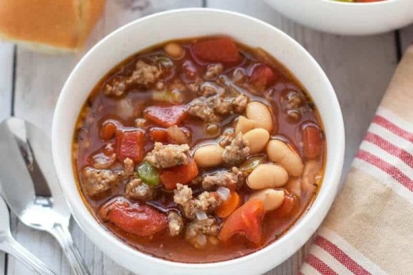 A bowl of sausage and bean soup.