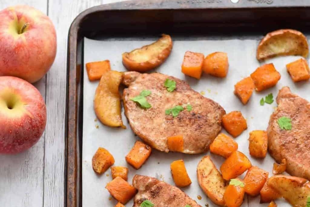 Pork chops cooking on a sheet pan.