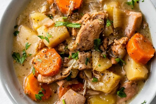 Slow cooker chicken stew in a white bowl.