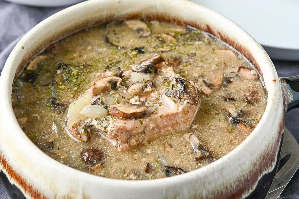 Pork chops on a plate served with potato.