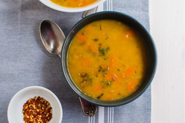 Smoked turkey and white bean soup in a black bowl.