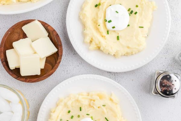 Mashed potatoes with butter served on a white, round plate. 