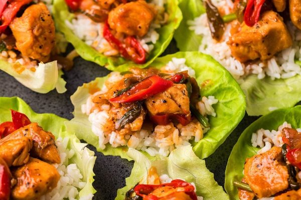 Spicy Gochujang Chicken Stir Fry served with rice on lettuce leaves.