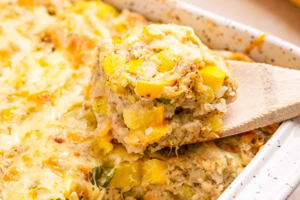 Squash casserole with a wooden spoon.