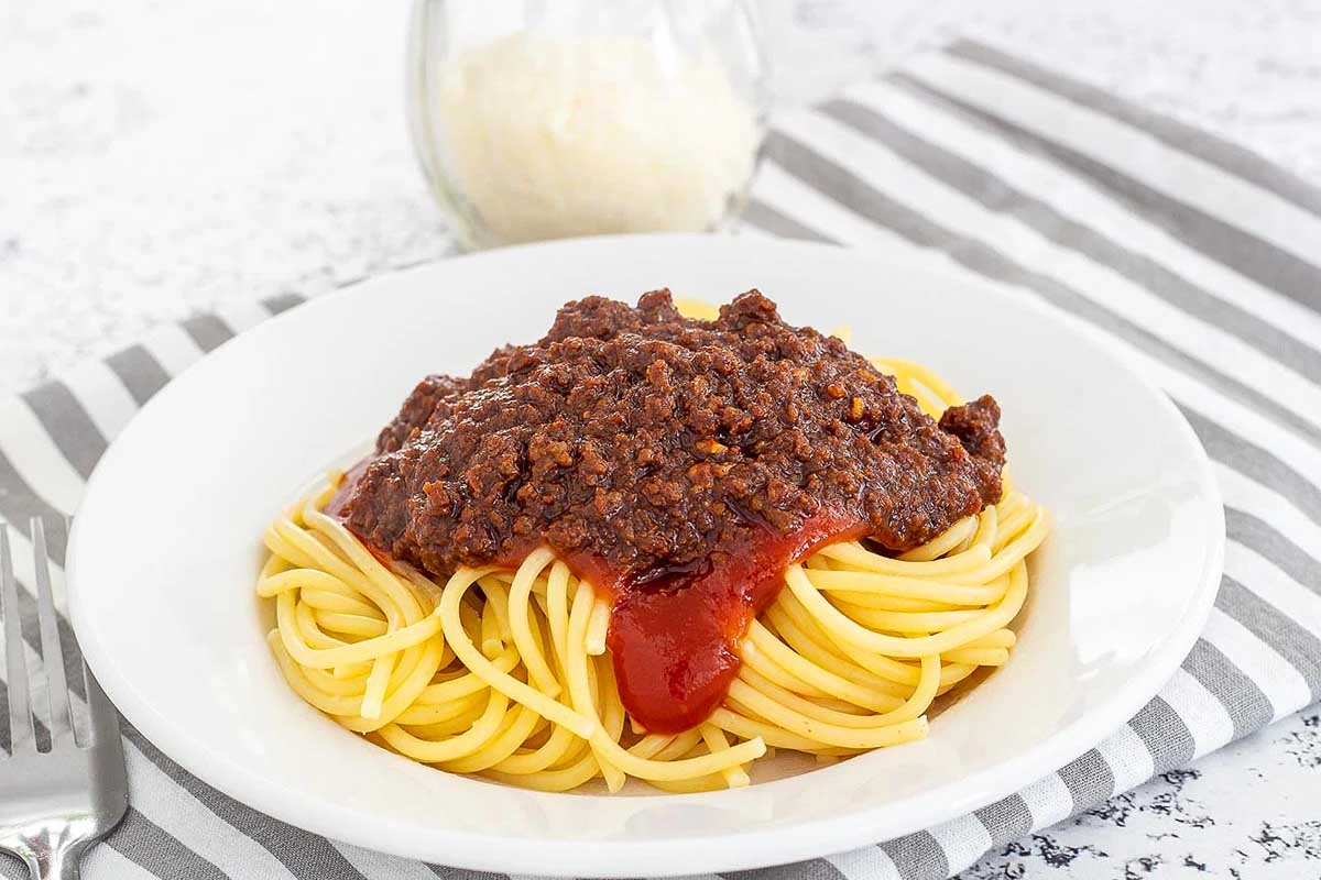 Steak ‘n Shake Copycat Chili-Mac in a white bowl with spaghetti on it.