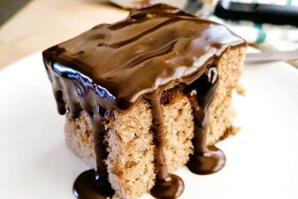Slice of toffee pudding cake with chocolate frosting.