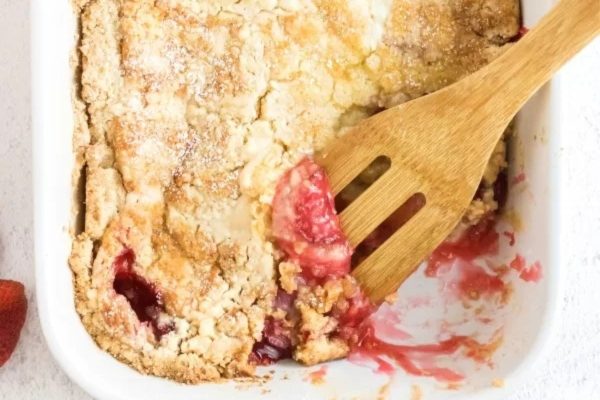Strawberry cake in a white casserole dish.