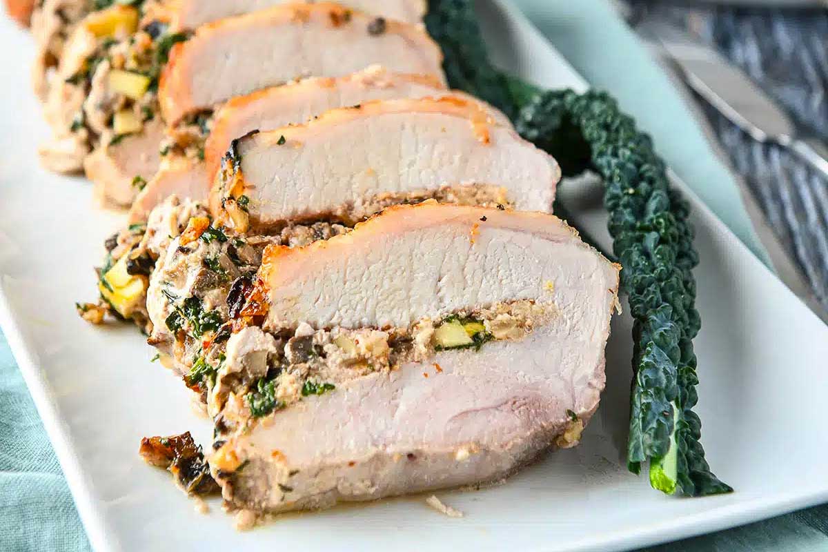 Stuffed pork loin on a white tray.