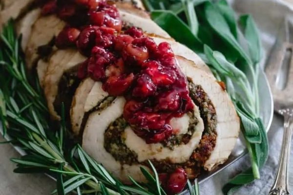 Slices of turkey roulade with cranberry sauce on top. 