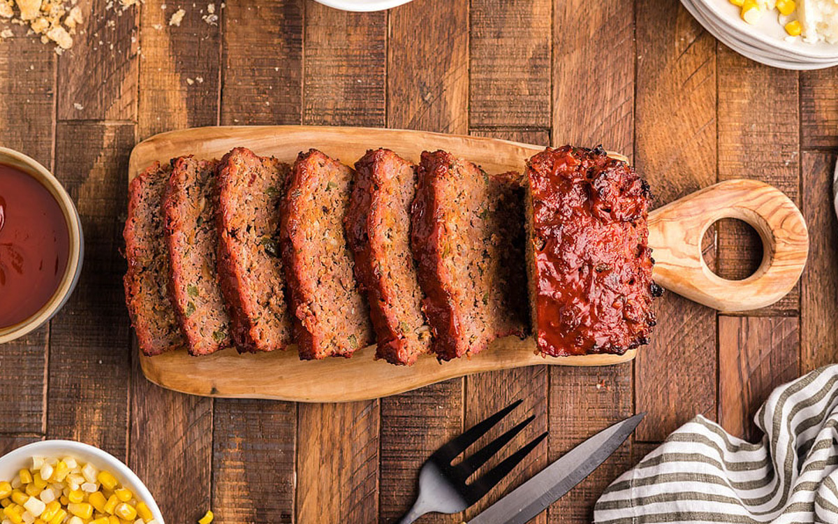 BBQ meatloaf sliced on wooden board.