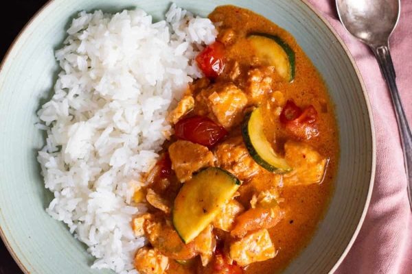 Creamy curry made of salmon, zucchini and and cherry tomatoes, served over rice.