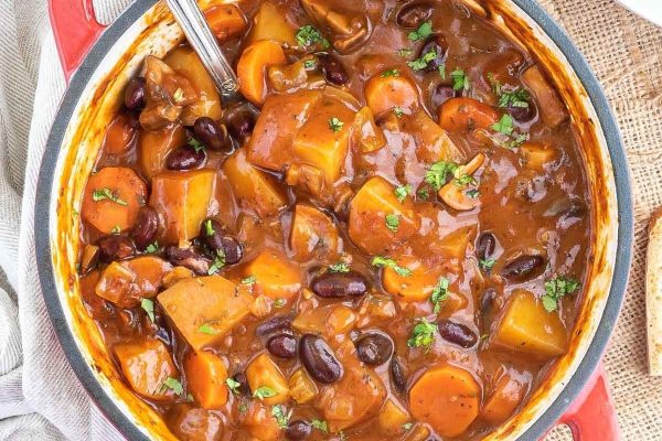 A pot of stew with beans, potatoes and carrots.