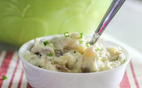 Bowl of mashed potatoes with herbs.