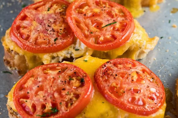 Tuna melt sandwich topped with tomato slices.
