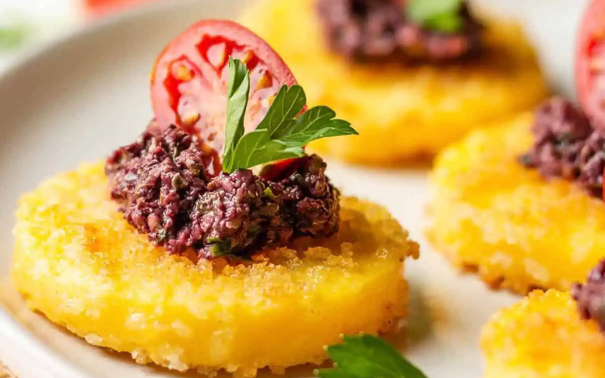 Polenta bites with tomato on top.