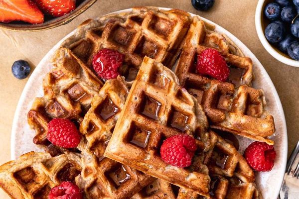 Waffles on a plate with berries and raspberries.