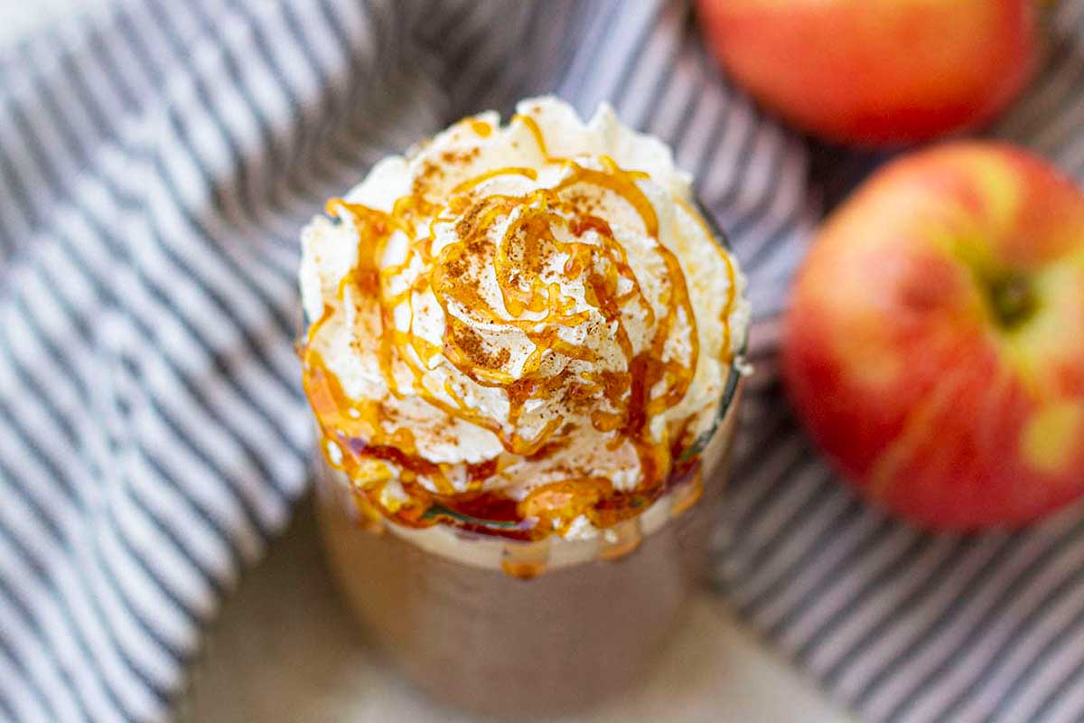 Apple crisp frappuccino with whipped cream topping in a glass.