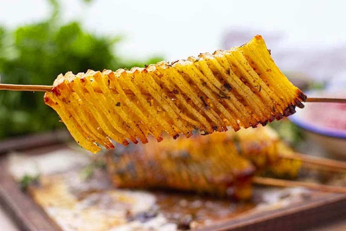 A skewer with an accordion cut potato. 