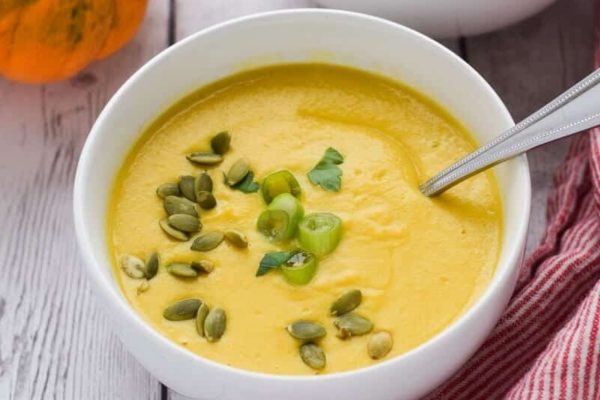 squash soup in a bowl with pepitas.
