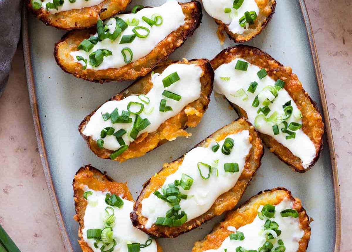 Potato skins with toppings on a plate .