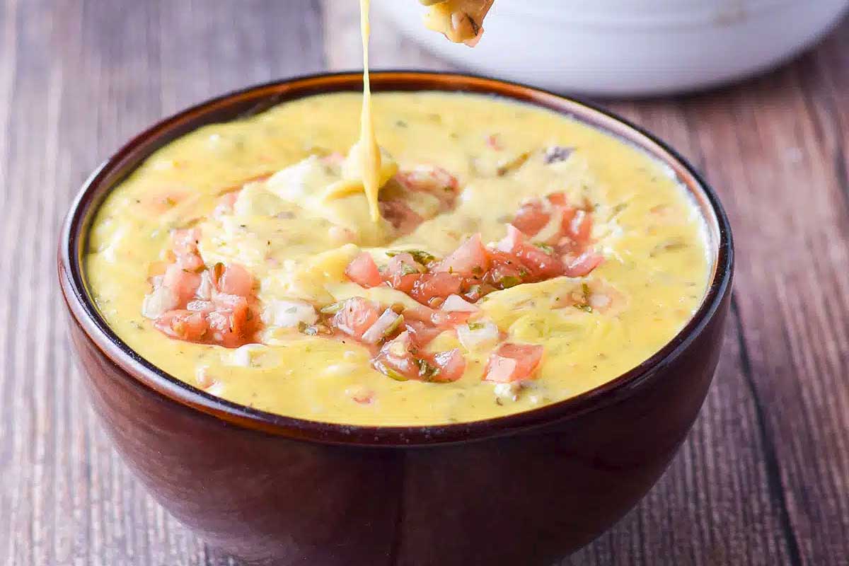 Beef and queso dip with diced tomatoes on top.