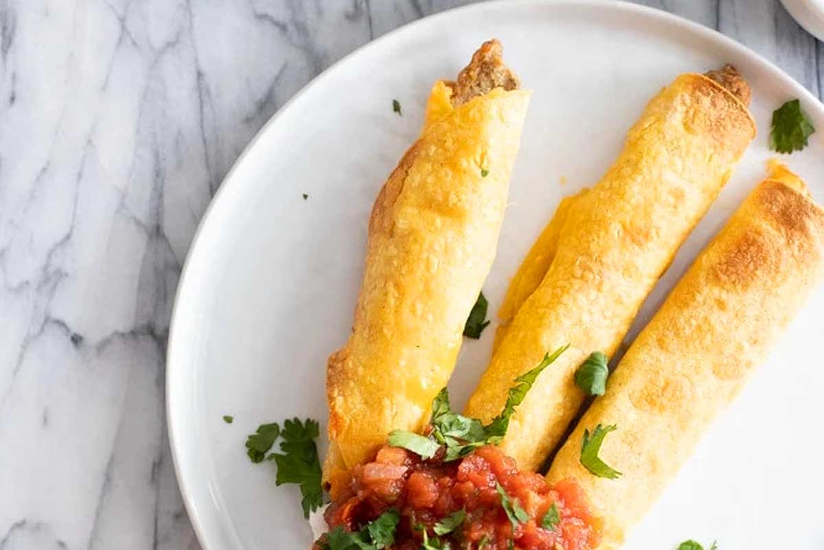 Golden brown air fried breakfast taquitos.