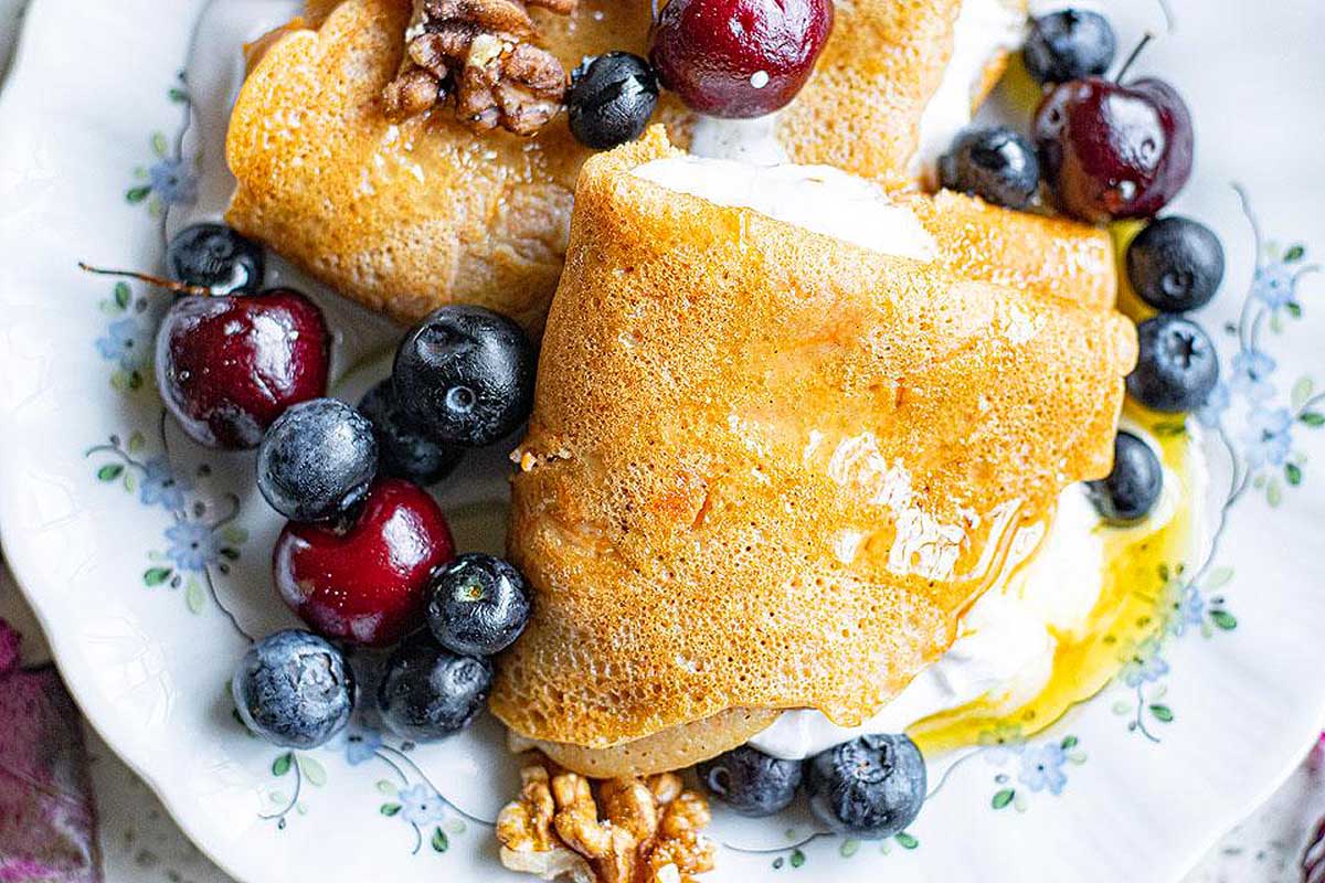 Carrot Cake Vegetable Crepes on a plate with fruit.