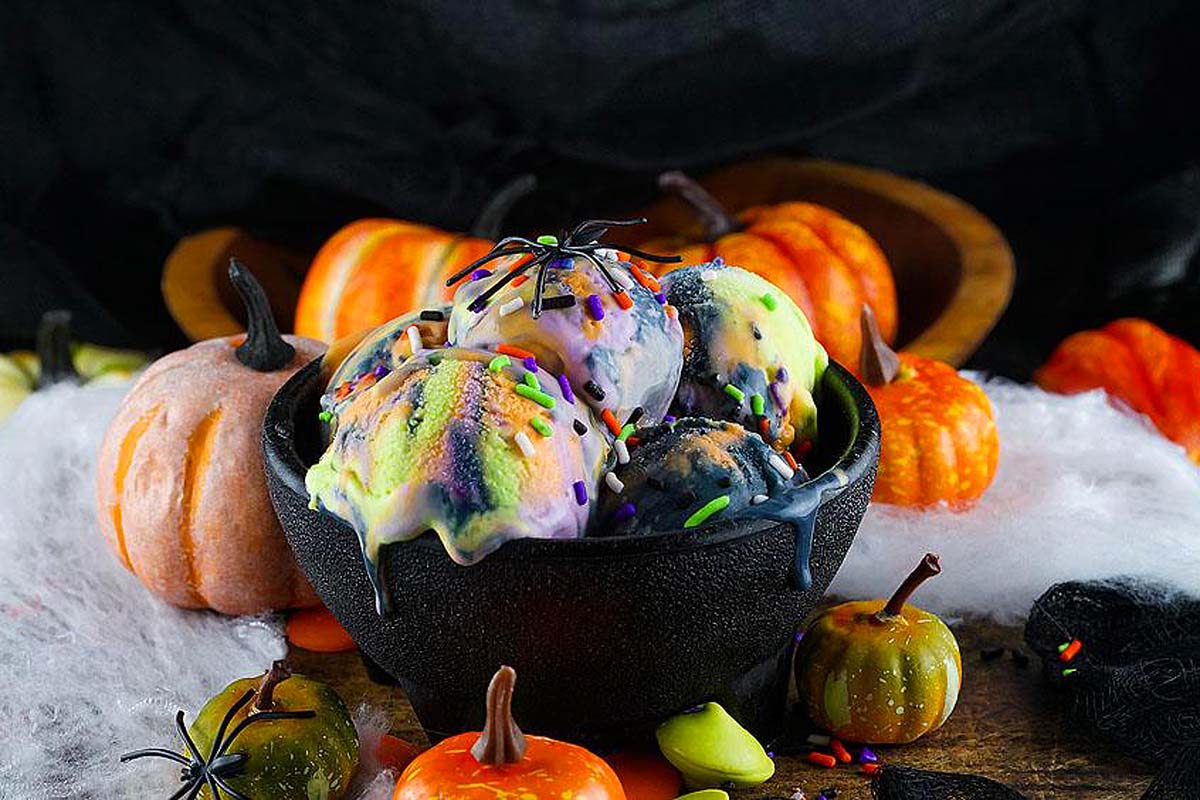 Orange, purple,green and black ice cream in a bowl.
