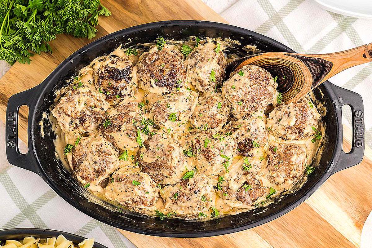 Ikeas meatballs being scooped from a casserole dish.
