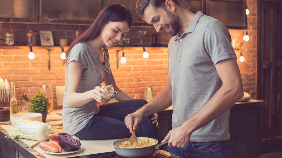 Couple cooking pasta in the kitchen.