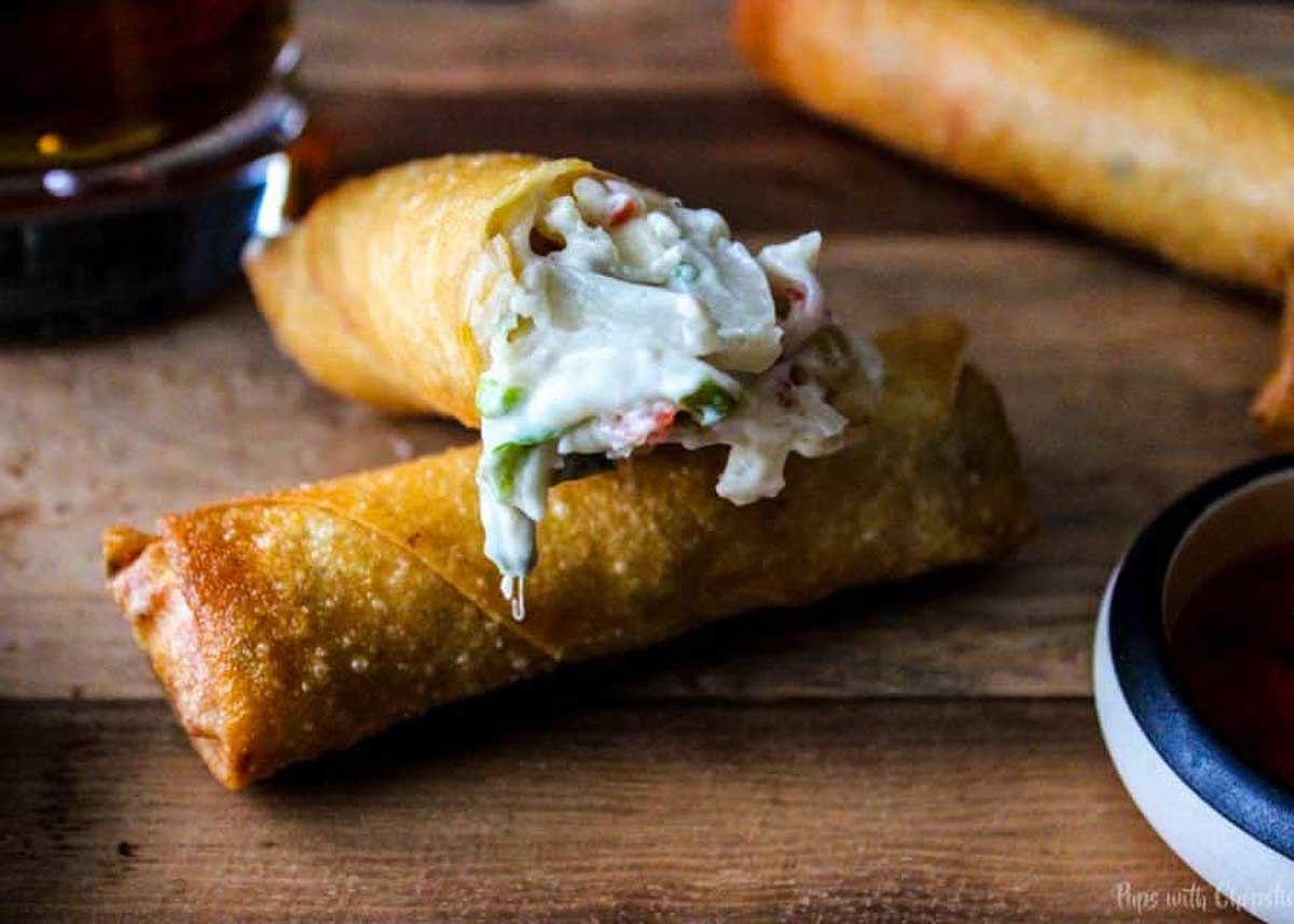 Spring roll cut in half to see crab and cheese inside.