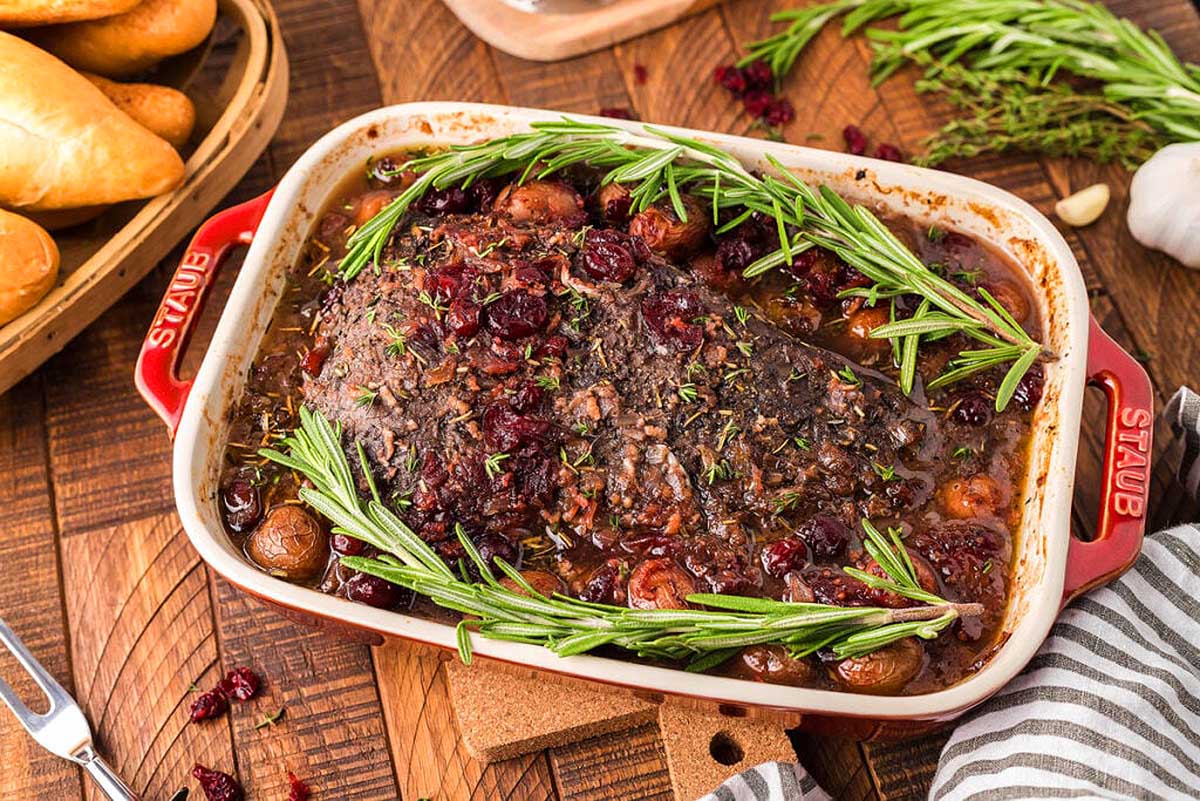 Cranberry holiday beef brisket in a red pan. 