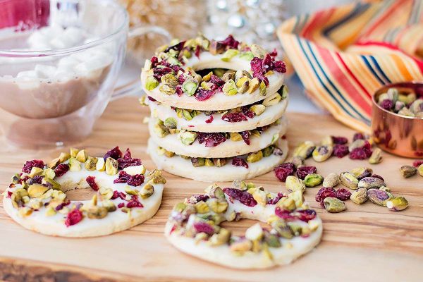 A stack of cranberry Lemon Pistachio Wreath Cookies.