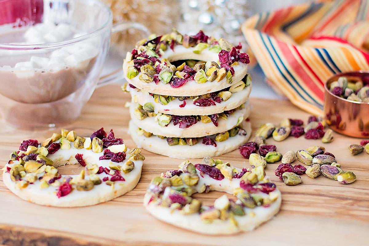 A stack of cranberry Lemon Pistachio Wreath Cookies.