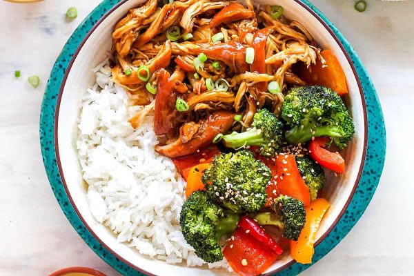 Crockpot chicken teriyaki in blue bowl with rice.