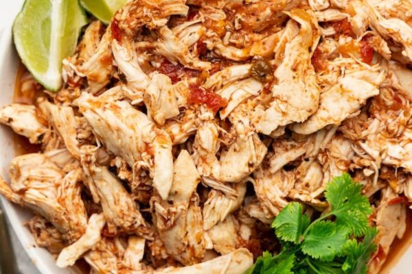 Crockpot salsa chicken shredded on a plate.
