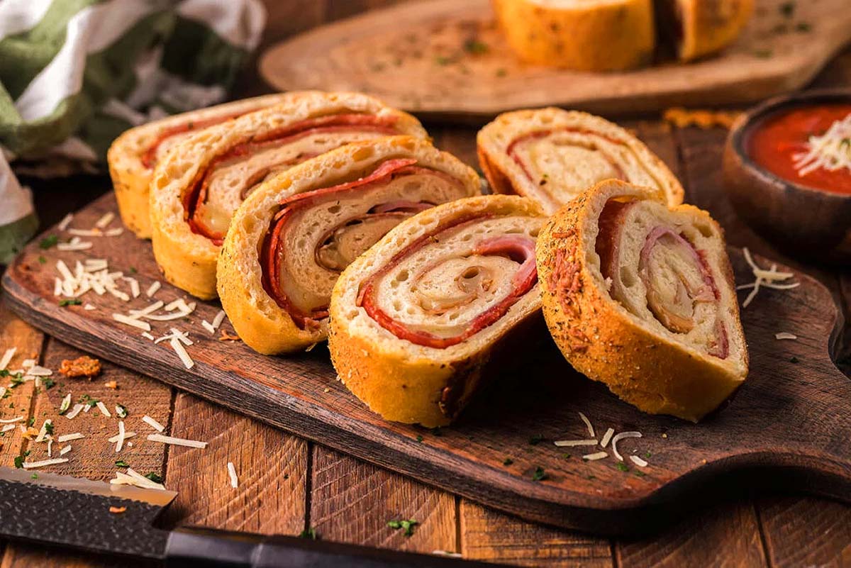 A stromboli sliced and on a cutting board.