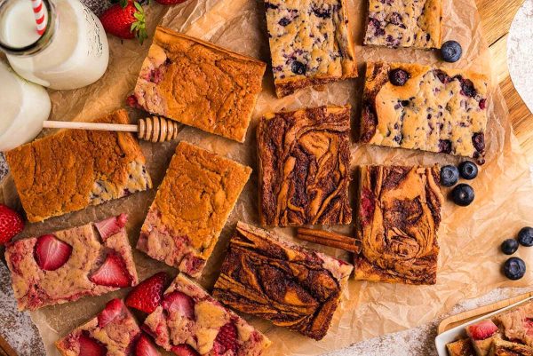 A variety of fruit and nut bars on a wooden board.