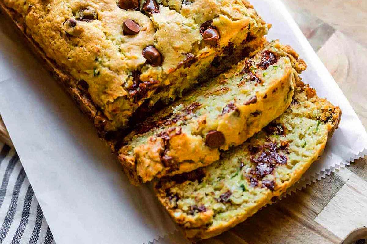A slice of chocolate chip zucchini bread on a cutting board.