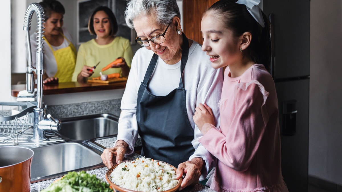 Grandmother and granddaughter cooking rice.