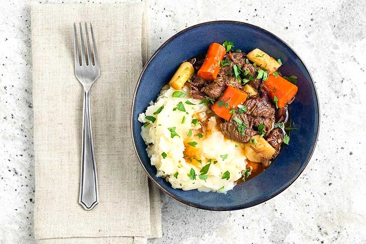 Beef Stew with mash potatoes in a blue bowl.