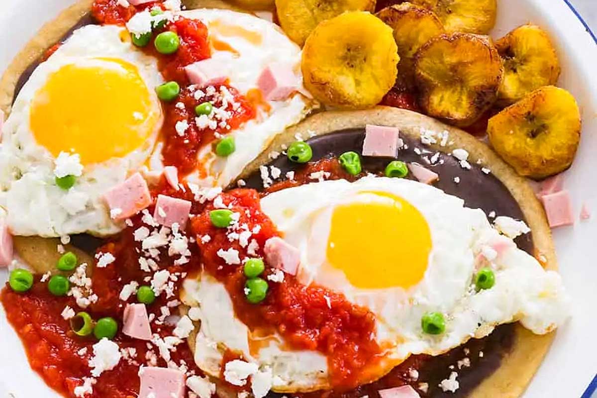 Colorful huevos motulenos with fried plaintains.