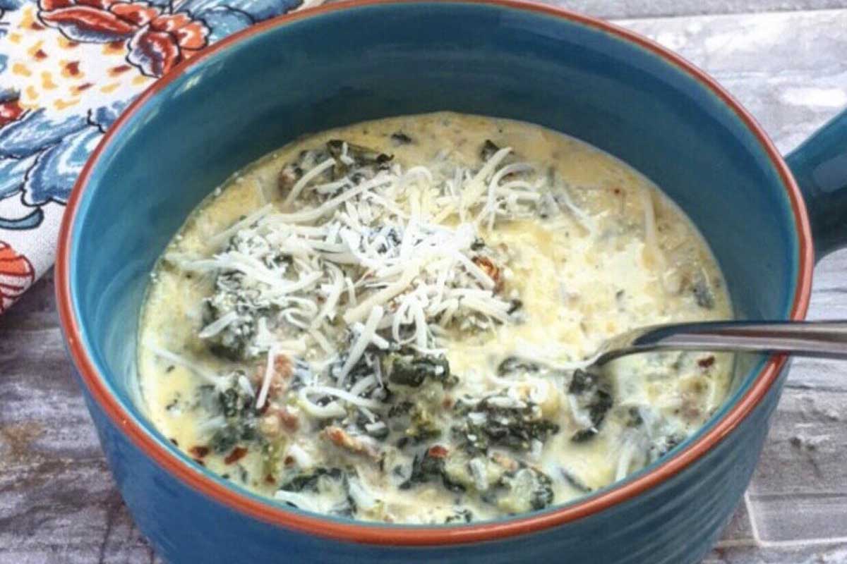 A bowl of soup with broccoli and cheese.