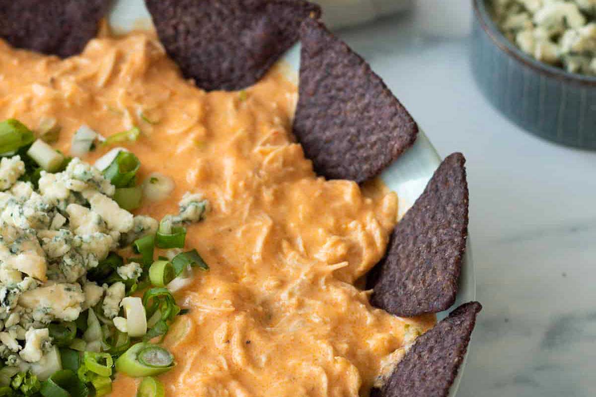 Buffalo chicken dip garnished with green onions.