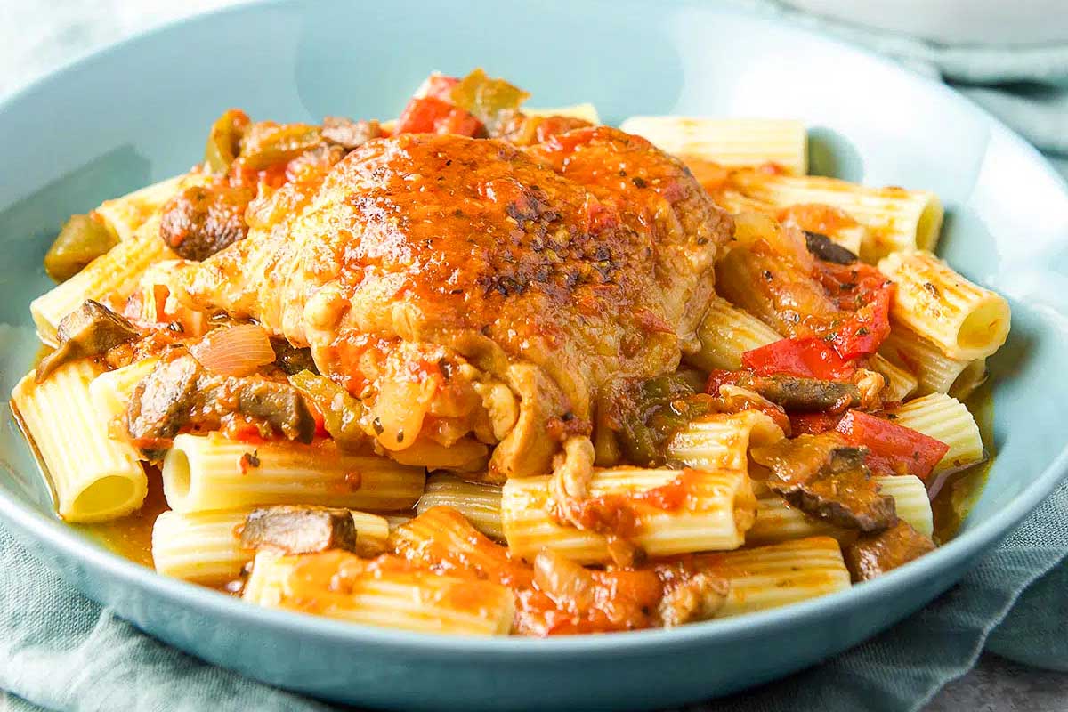 Colorful chicken cacciatore over pasta.