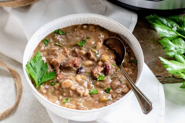 Instant pot bean soup in a white bowl.